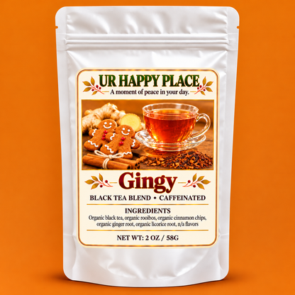A stand-up pouch of Ur Happy Place Gingy Black Tea Blend, shown against a solid orange background. The white resealable pouch features a large, detailed label with gingerbread cookies, cinnamon, and a cup of tea, along with text detailing the ingredients and net weight of 2 oz (58g).
